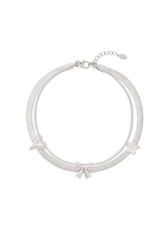 Zilveren enkelband met een schattig strikje, een speelse en elegante toevoeging aan je zomeroutfits.