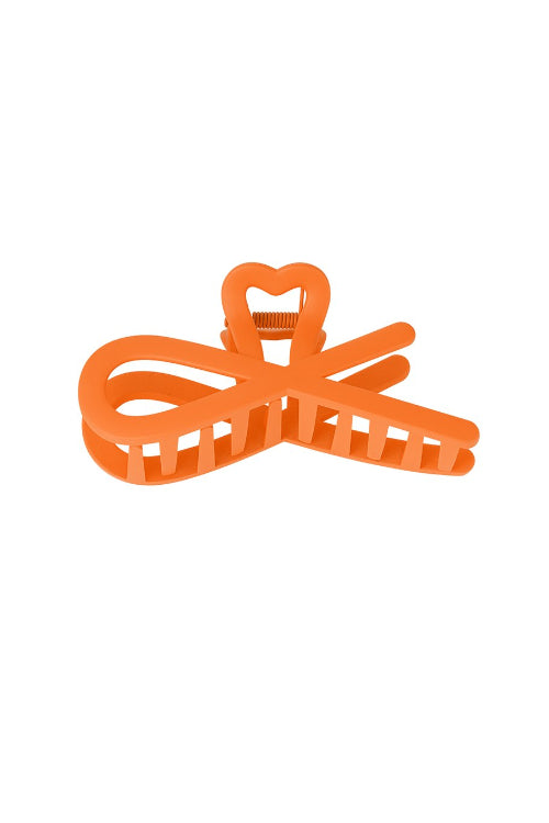 Oranje haarclip met krullend design, ideaal voor een speelse en zomerse haarlook.